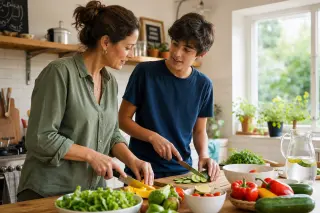 A woman and her teenage son preparing a fresh salad together in a bright, cozy kitchen, engaged in a calm, healthy routine.